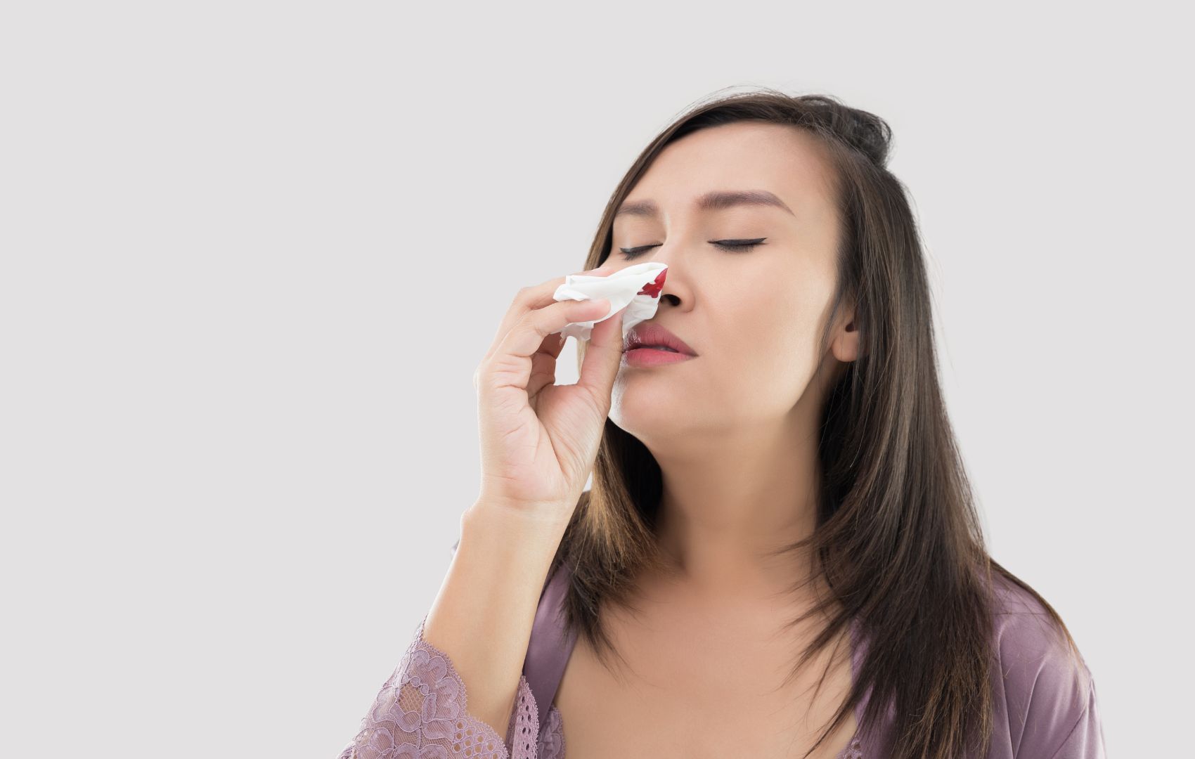 mulher com epistaxe (sangramento nasal), possível efeito colateral do avamys